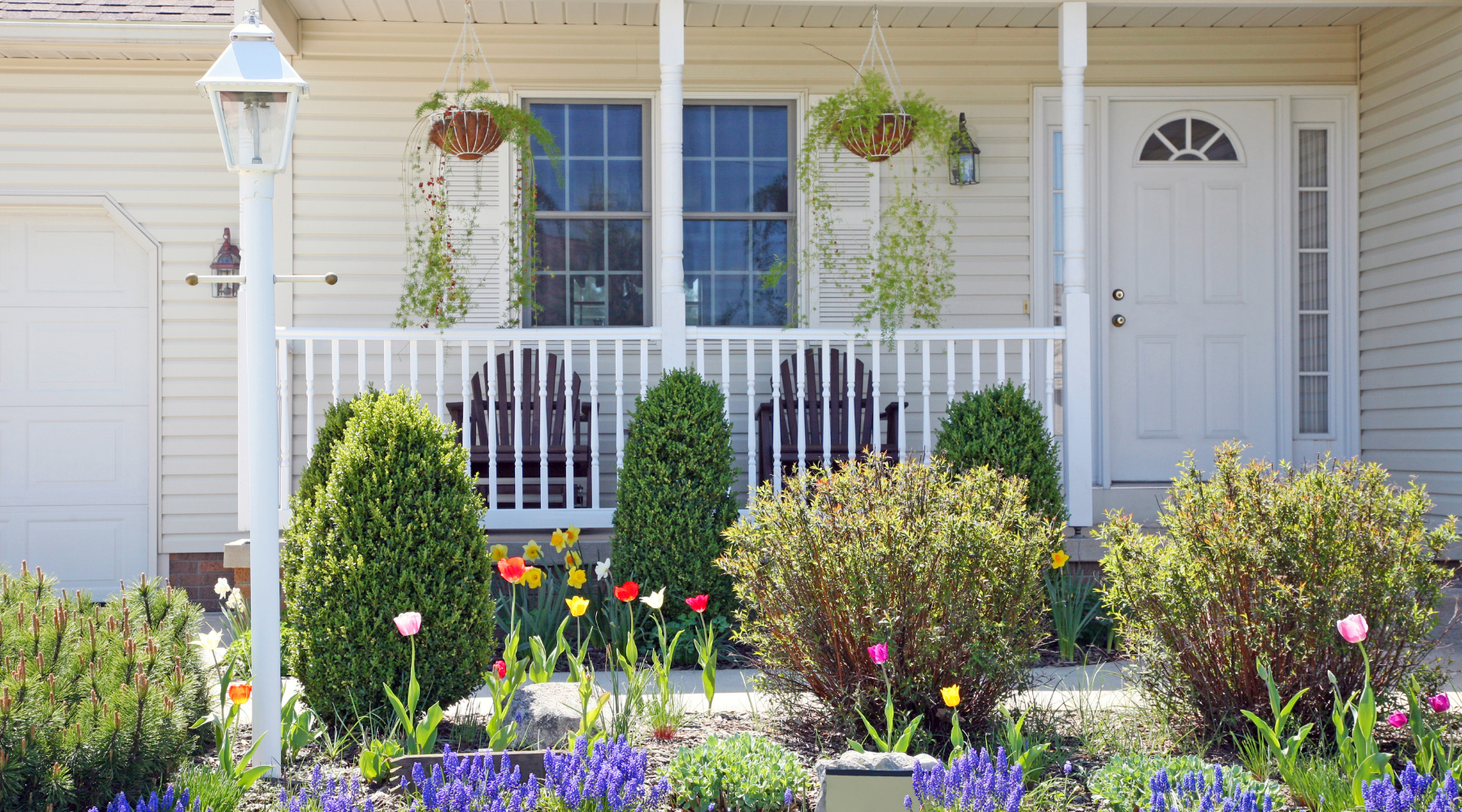 Shot of white home front porch with spring florals in front