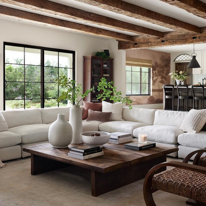 Cozy living room with white sectional and wood beams across ceiling