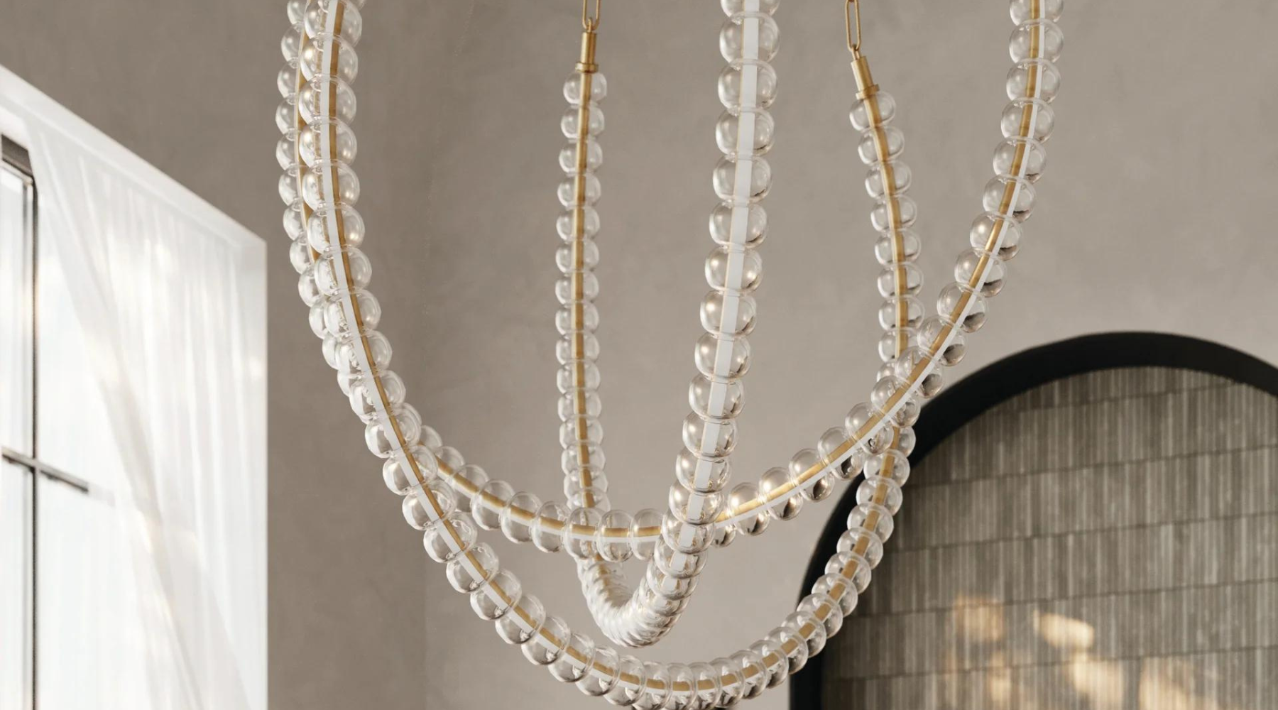 Large crystal chandelier hanging with a grey wall background