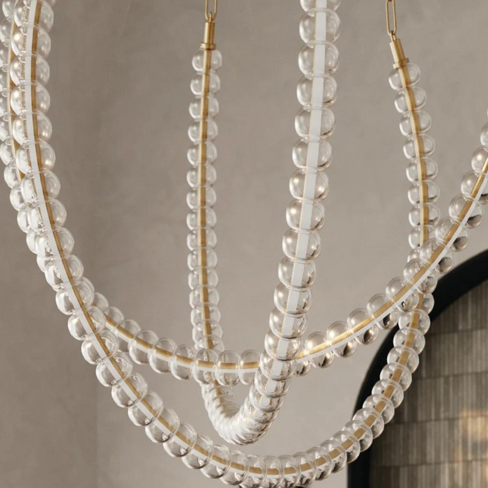 Large crystal chandelier hanging with a grey wall background