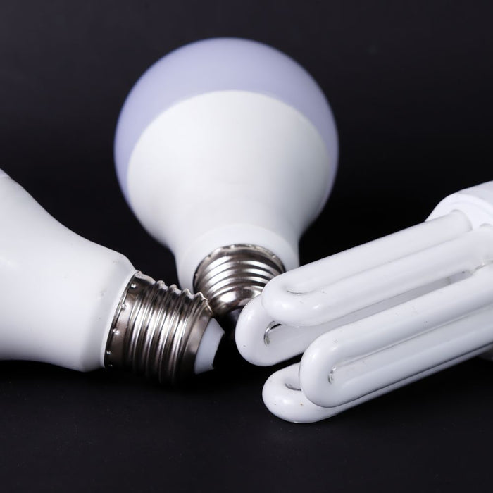 Three light bulbs sitting on a black surface