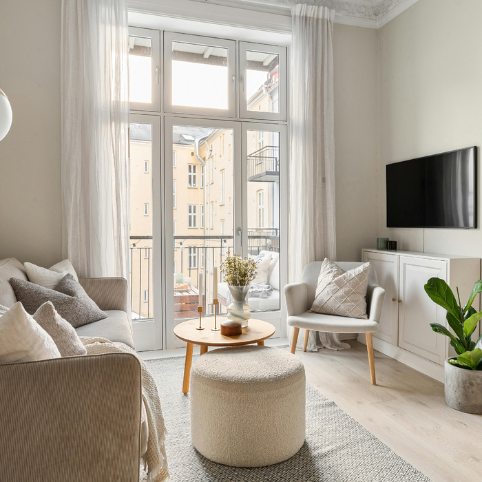 Small aparment living room with a grey couch, gold floor lamp and view of the counter and range hood