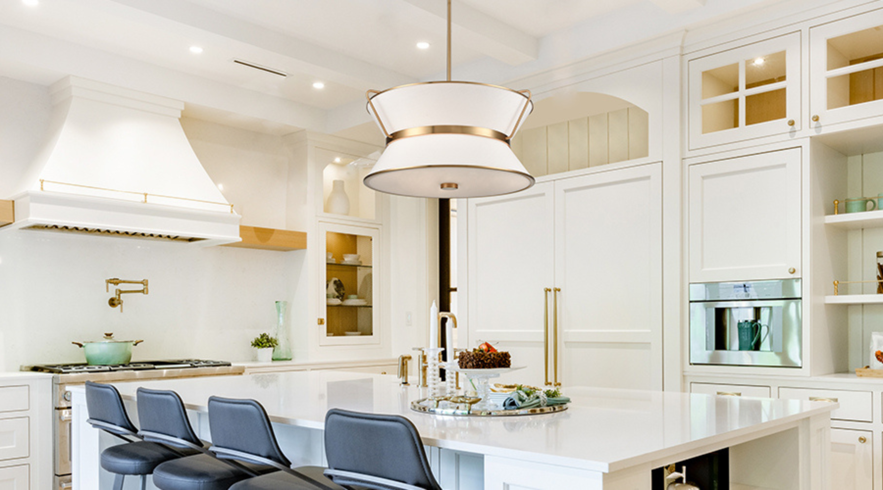 White kitchen with a single large pendant hanging over the island