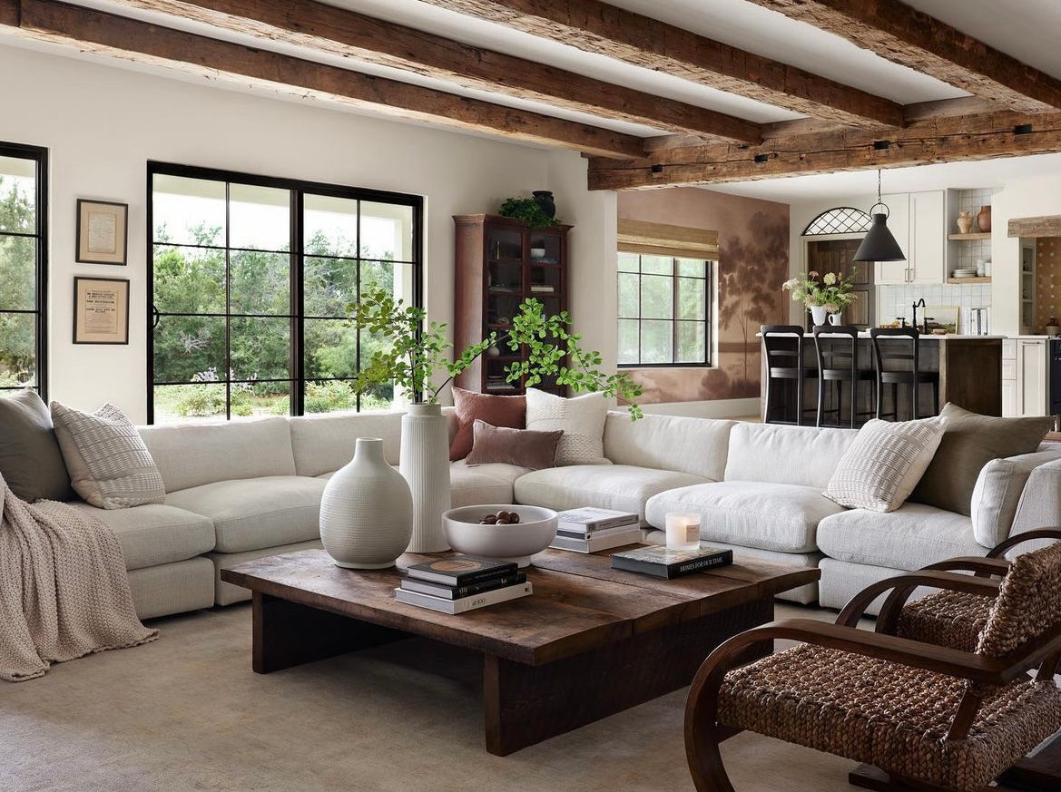 Cozy living room with white sectional and wood beams across ceiling