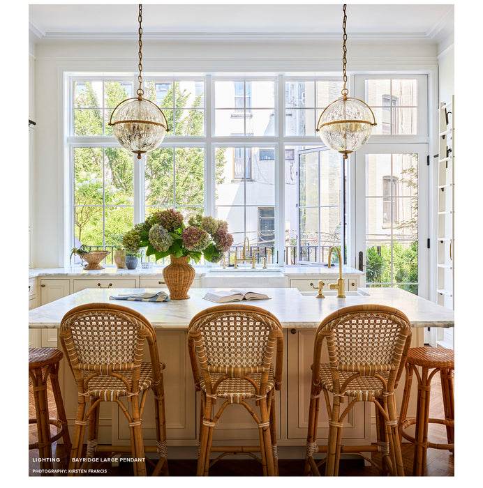 Dining area with a large window, white table, and wicker chairs.