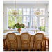 Dining area with a large window, white table, and wicker chairs.