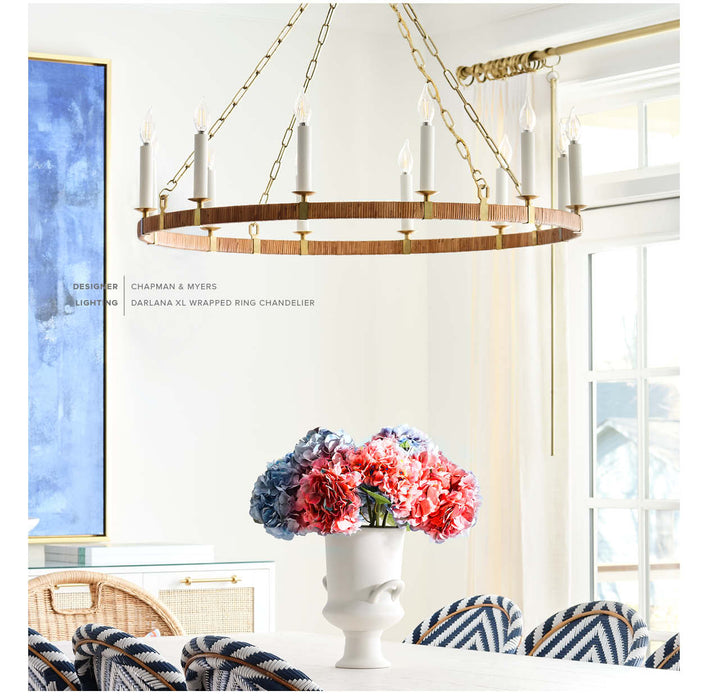 Chandelier hanging above a table with flowers in a room with a large window.