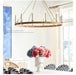 Chandelier hanging above a table with flowers in a room with a large window.