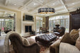 Living room with brown furniture, fireplace, and large windows.