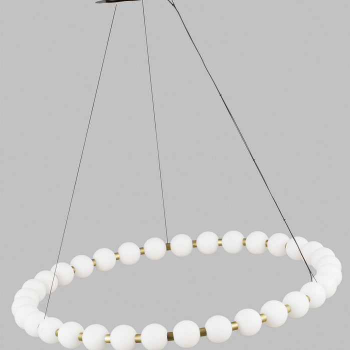Brass fixture on wire cords holding brass ring with white glass. 