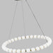 Brass fixture on wire cords holding brass ring with white glass. 