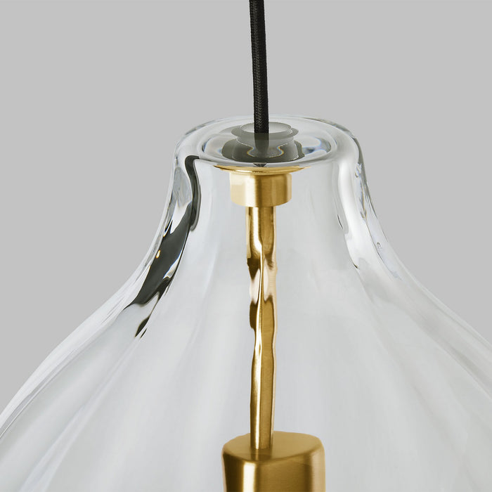 Close-up of a clear glass pendant light with gold accents on a gray background