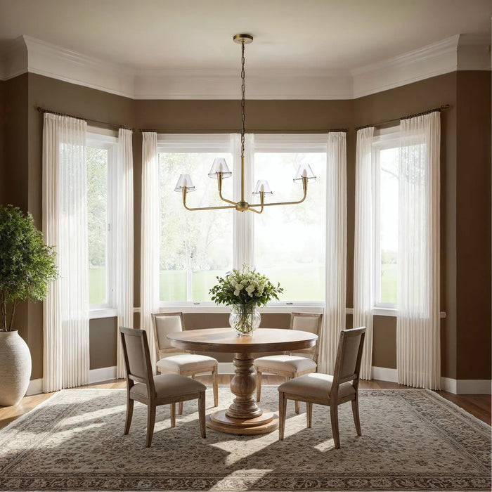 Dining room with a round wooden table, chairs, and a chandelier.