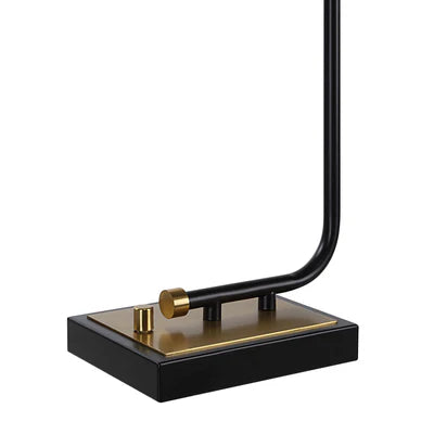 Close-up of a sleek black and gold lamp base with a minimalist curved metal frame and square platform design.