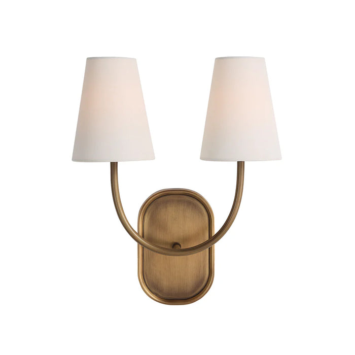 Brass double wall sconce with curved arms and white tapered fabric shades.