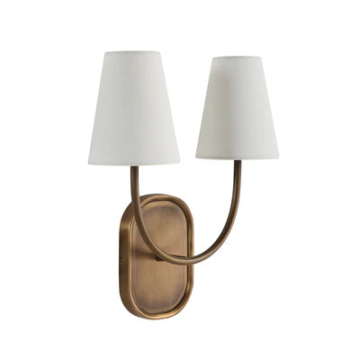 Brass double wall sconce with curved arms and white tapered fabric shades.