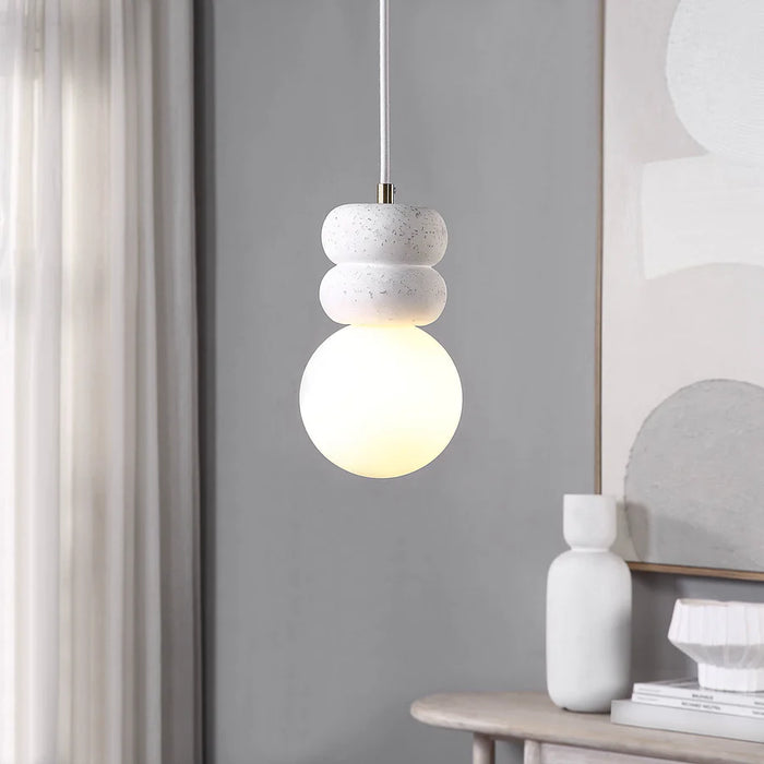 Contemporary interior with a pendant light featuring stacked white stone accents and a glowing frosted glass globe.