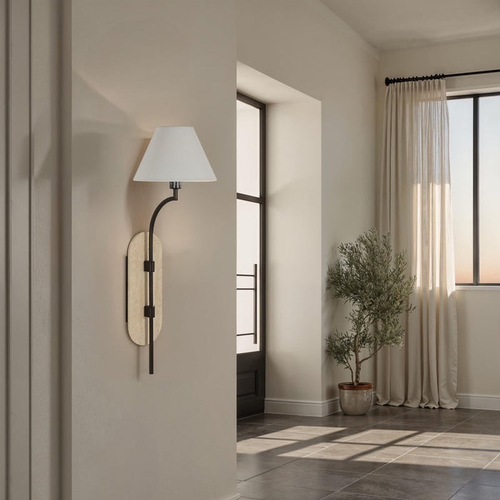 Wall-mounted lamp on a beige wall in a room with a plant and a window.