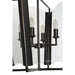 Close-up of a black lantern pendant light with curved glass panels and candle-style bulbs.