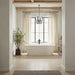 Modern bathroom with freestanding tub, tall windows, exposed wood beams, and black lantern pendant lighting.
