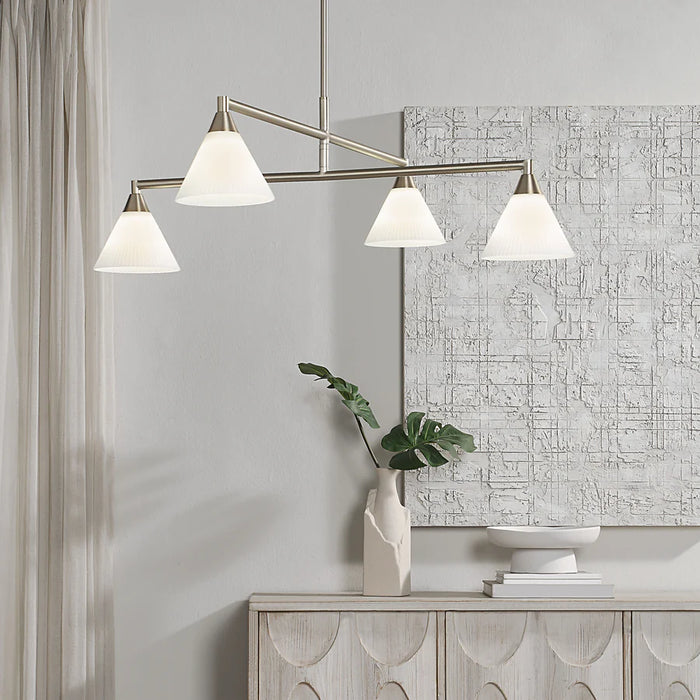 Contemporary interior with a brushed nickel linear chandelier and four illuminated white cone shades.