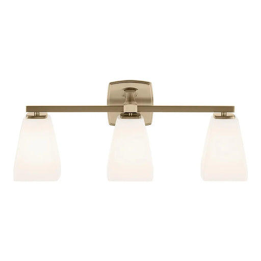 A three-light bathroom vanity light fixture with a brushed brass horizontal bar, a square backplate, and three tapered frosted glass shades, shown against a plain white background.