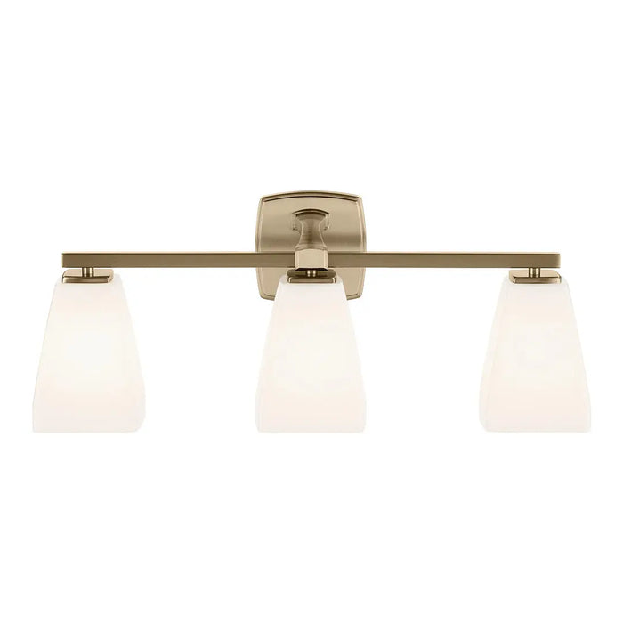 A three-light bathroom vanity light fixture with a brushed brass horizontal bar, a square backplate, and three tapered frosted glass shades, shown against a plain white background.