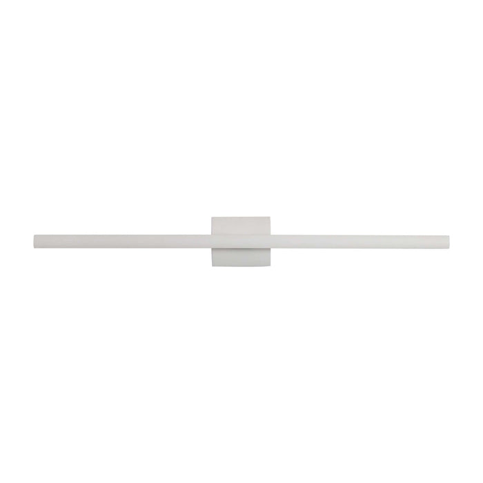 A minimalist wall-mounted light fixture with a long horizontal bar and a central square plate, shown in a very light warm gray or off-white finish against a solid white background.