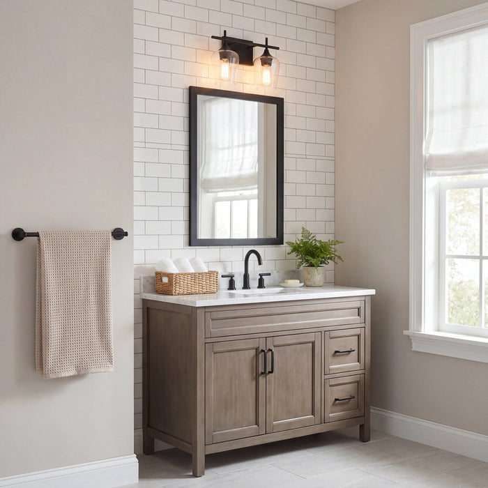 A rustic gray-brown wooden bathroom vanity with a white countertop, black faucet, and a black-framed mirror, set against a white subway tile wall in a bright bathroom.