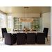 A luxury dining room setup featuring a white rectangular dining table surrounded by eight black upholstered chairs. A large modern chandelier with a clear glass cylinder and gold-toned metal hangs over the table.