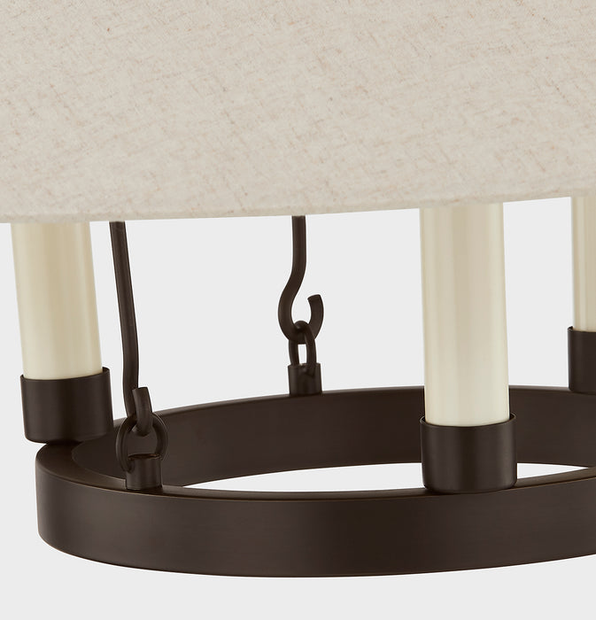 Close-up of a chandelier with black metal frame and white candle-like lights on a neutral background