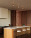 Modern kitchen with wooden cabinets, island, and bar stools.