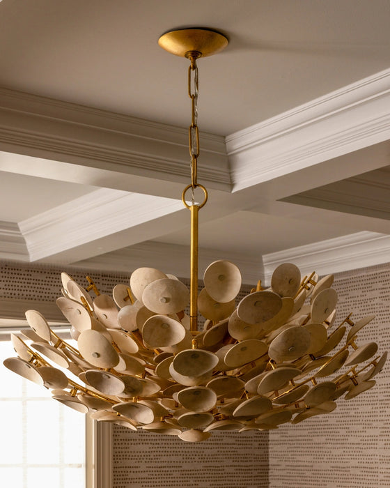 Organic chandelier hanging from a moulded ceiling. 