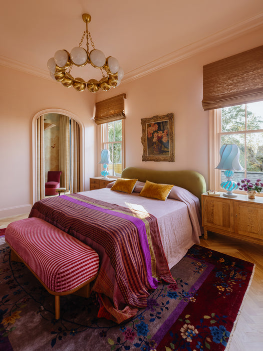 Luxurious bedroom with a chandelier, bed, and decorative elements.