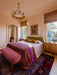 Luxurious bedroom with a chandelier, bed, and decorative elements.