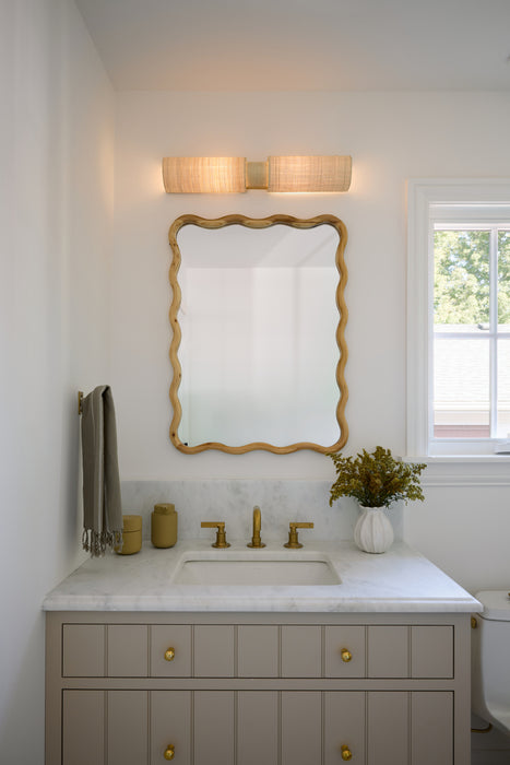 Bathroom vanity with gold-framed mirror, sink, and decorative items.