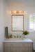 Bathroom vanity with gold-framed mirror, sink, and decorative items.