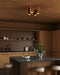 Modern kitchen with wooden cabinets, a marble island, and decorative elements.