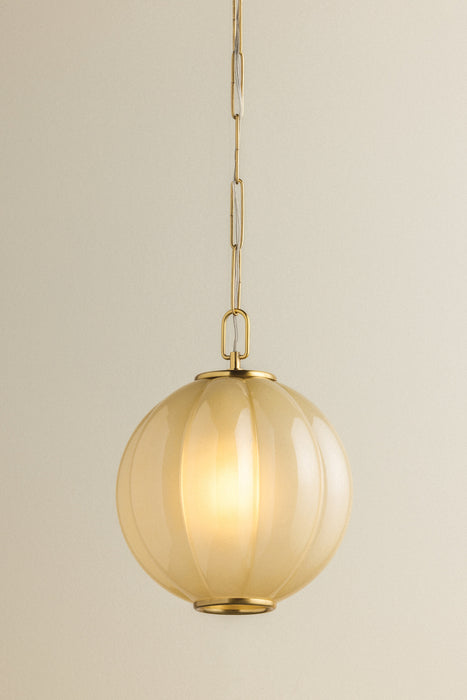 Gold pendant light with a beige glass shade on a neutral background