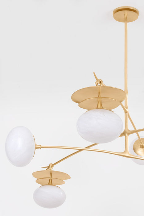 Modern chandelier with gold frame and white glass shades on a light gray background