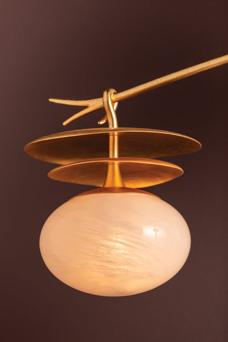 Decorative lamp with gold fixture and white glass shade on a dark background