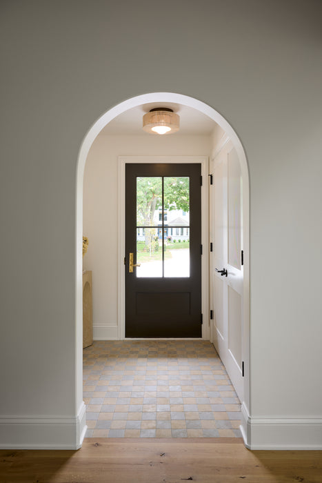 Archway leading to a room with a dark door and tiled floor.