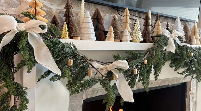 Angled shot of fire place with garland and tree decor