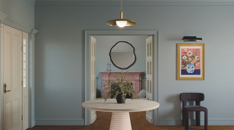 Dining room with a round table, chairs, and decorative elements on a gray wall.