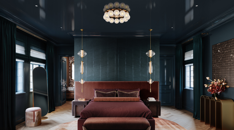 Moody, luxurious bedroom with deep blue walls, a burgundy bed, and crystal pendant lights flanking the headboard.