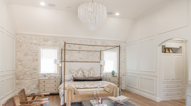 A image of a European chic bedroom with unique details like crown molding and a floral bedspread 