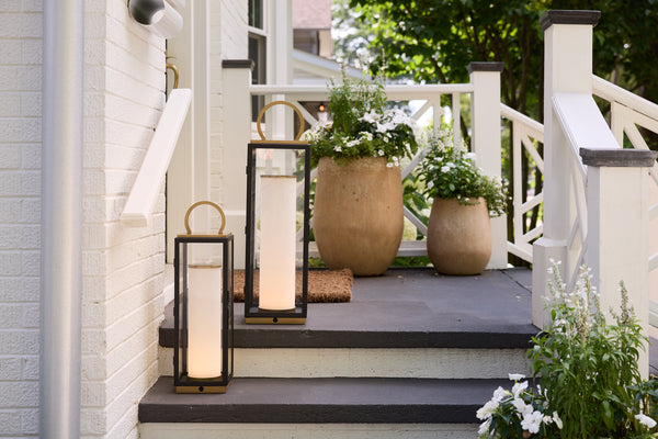 Decorative outdoor steps with lanterns and potted plants on a house porch.