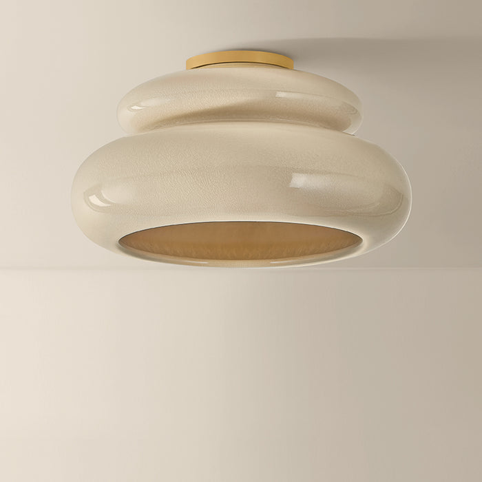Ceiling light fixture with beige and gold design on a plain background