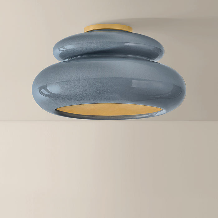 Ceiling light fixture with blue and gold design on a beige background