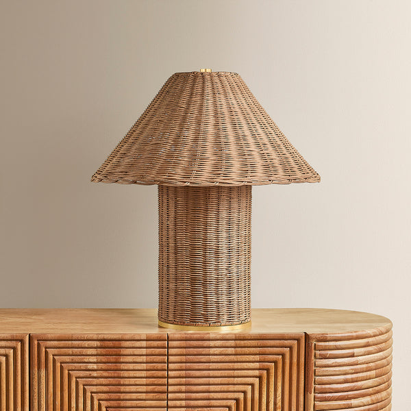 Wicker table lamp on a wooden surface with a neutral background